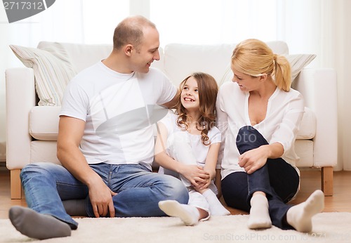 Image of parents and little girl sitting on floor at home
