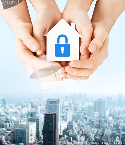 Image of hands holding paper house with lock