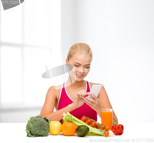 Image of woman with vegetables pointing at smartphone