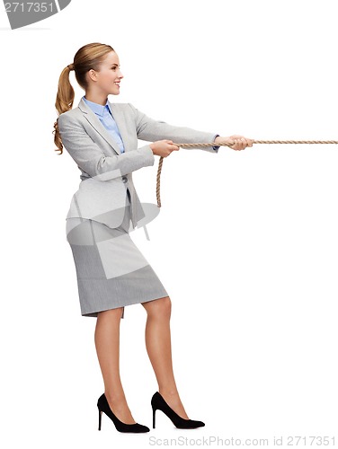 Image of smiling businesswoman pulling rope