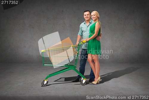 Image of smiling couple with shopping cart and big box