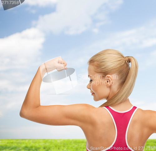 Image of sporty woman showing her biceps