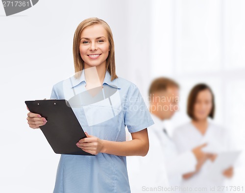 Image of smiling female doctor or nurse with clipboard