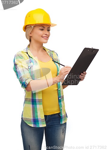 Image of smiling woman in helmet with clipboard