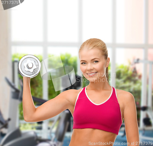 Image of smiling woman with heavy steel dumbbell