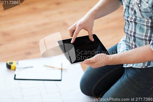 Image of male with tablet pc, blueprint and measuring tape