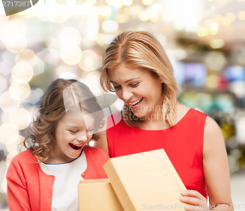 Image of smiling mother and daughter opening gift box