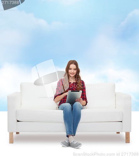 Image of teenage girl sitting on sofa with tablet pc