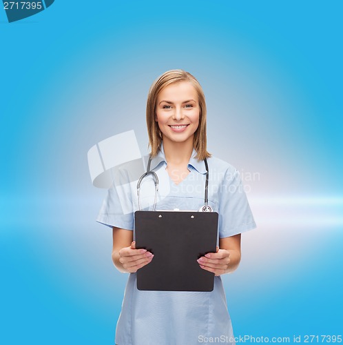 Image of smiling female doctor or nurse with clipboard