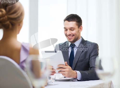 Image of smiling man looking at menu on tablet pc computer