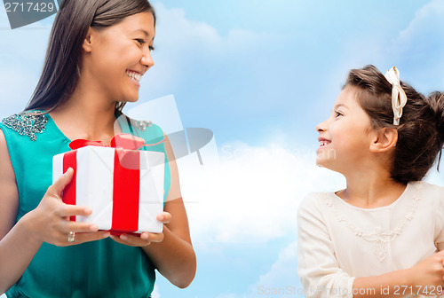 Image of happy mother and child girl with gift box