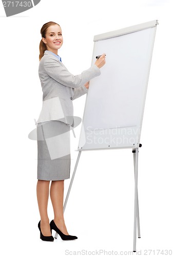Image of smiling businesswoman writing on flip board