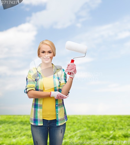 Image of smiling woman in gloves with paint roller