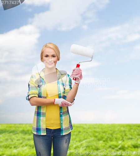 Image of smiling woman in gloves with paint roller