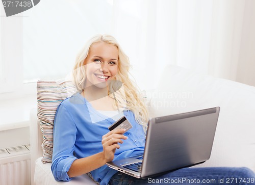 Image of smiling woman with laptop computer and credit card