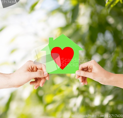 Image of couple hands holding green paper house