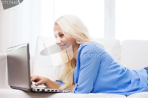 Image of smiling woman with laptop computer at home