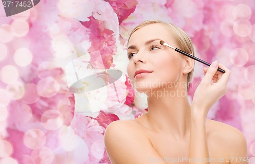 Image of beautiful woman with makeup brush