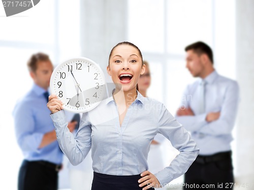 Image of attractive businesswoman with wall clock