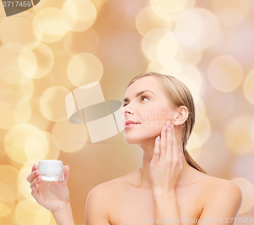 Image of woman applying cream on her skin