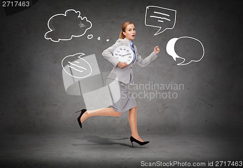 Image of stressed young businesswoman with clock running