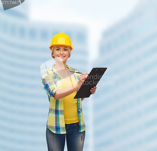 Image of smiling woman in helmet with clipboard