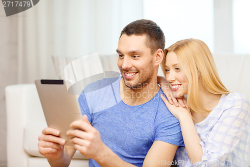 Image of smiling happy couple with tablet pc at home