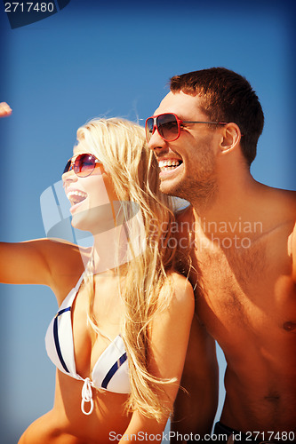 Image of happy couple in sunglasses on the beach