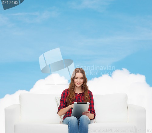 Image of teenage girl sitting on sofa with tablet pc