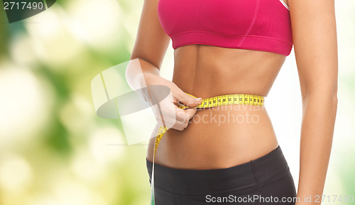 Image of close up trained belly with measuring tape