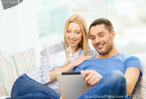 Image of smiling happy couple with tablet pc at home