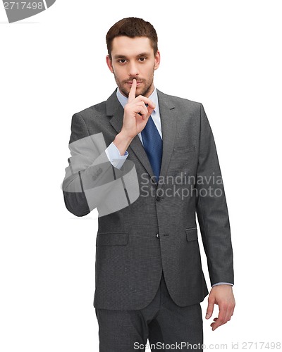 Image of handsome businessman with finger on his lips