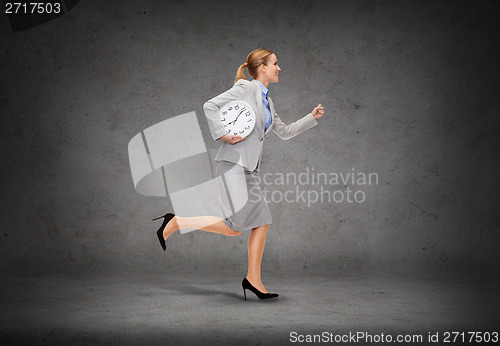 Image of smiling young businesswoman with clock running