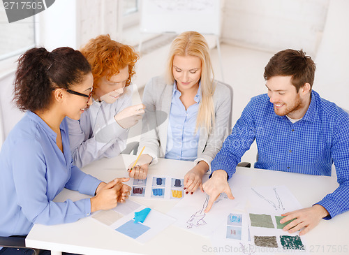 Image of smiling creative team looking at sketch