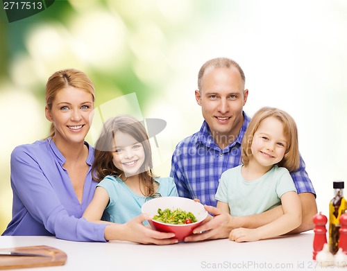 Image of happy family with two kids with salad at home