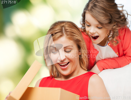 Image of smiling mother and daughter opening gift box