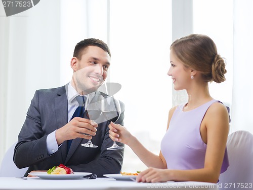 Image of couple with main course and red wine at restaurant