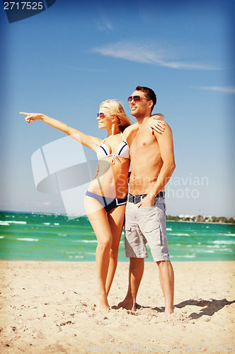 Image of happy couple in sunglasses on the beach