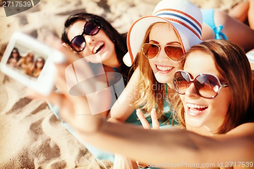 Image of girls making self portrait on the beach