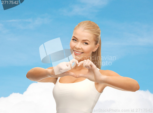 Image of smiling woman showing heart shape gesture