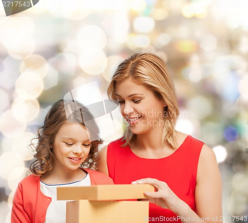 Image of smiling mother and daughter with gift box