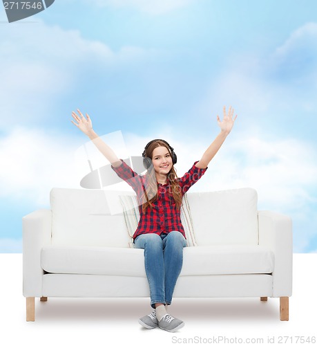 Image of teenage girl sitting on sofa with headphones