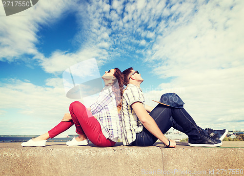 Image of teenagers sitting back to back