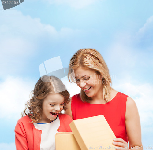 Image of smiling mother and daughter with gift box