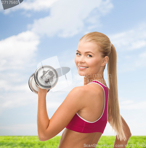 Image of smiling woman with heavy steel dumbbell