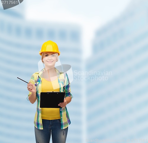 Image of smiling woman in helmet with clipboard