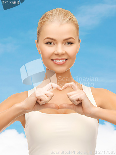 Image of smiling woman showing heart shape gesture