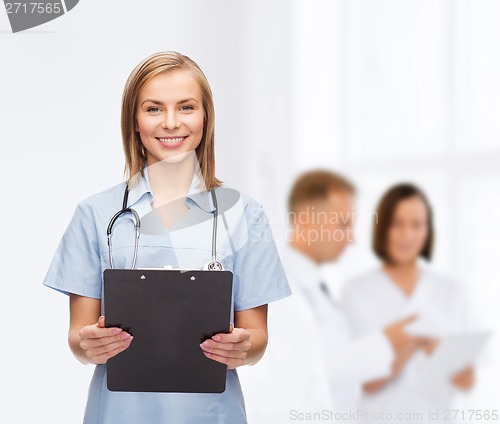 Image of smiling female doctor or nurse with clipboard