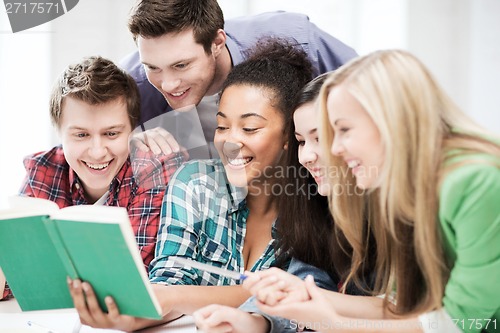 Image of students reading book at school