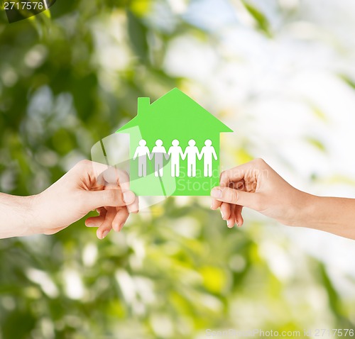 Image of man and woman hands with paper house